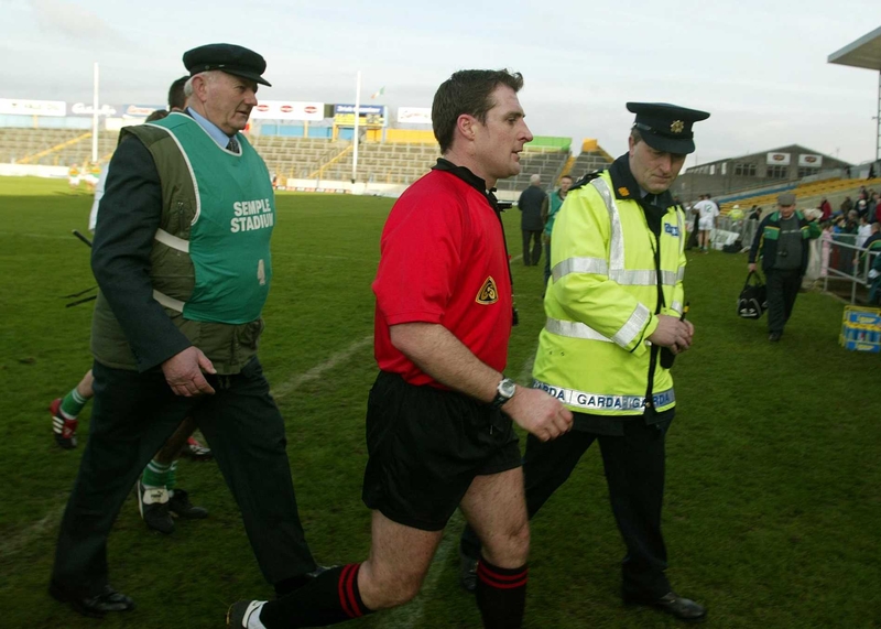 Ref Seamus Roche is escorted from the pitch during the drawn All-Ireland Club semi-final between O'Loughlin Gaels and Newtownshandrum in Ferbuary.