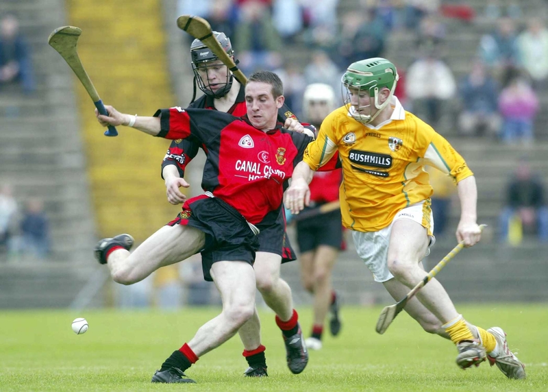 Gary Savage of Down clears the ball as Johnny Campbell of Antrim closes in