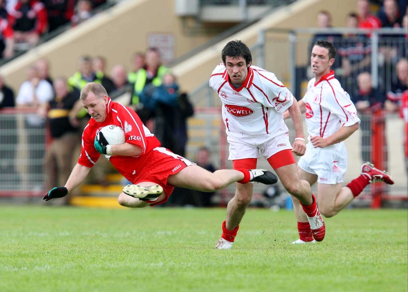 Johnny McBride of Derry is tackled by Tyrone's Joe McMahon