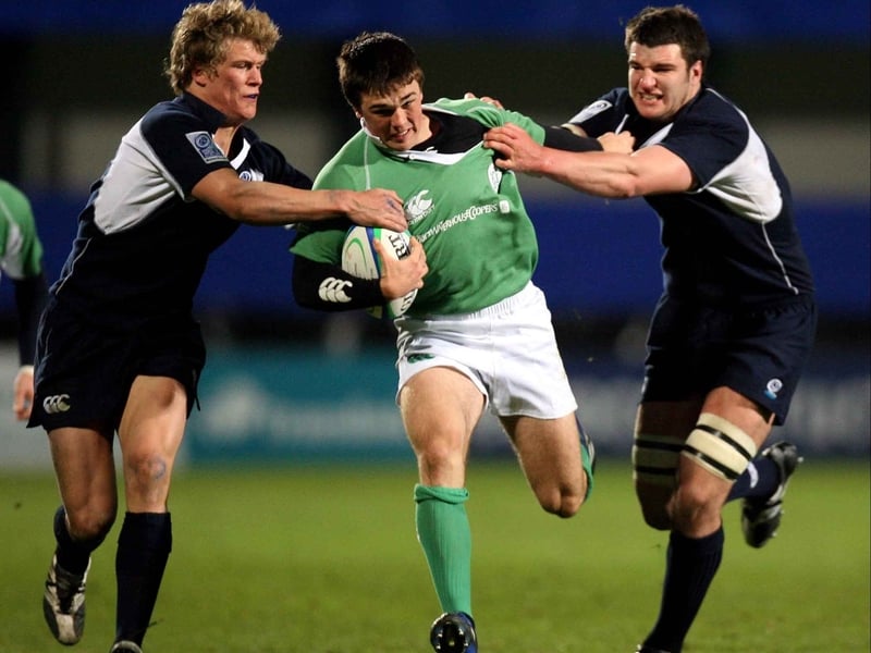Eoin O'Malley attempts to evade two Scottish tacklers