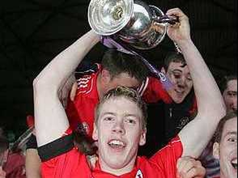 Cork captain Andrew O'Sullivan holds the trophy aloft