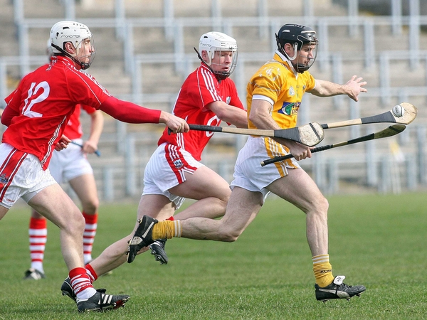 Antrim's Ciaran Herron is pursued by Kevin Canty and Timmy McCarthy (l) of Cork