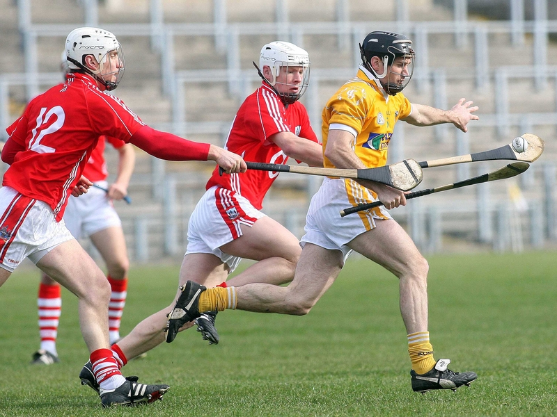 Antrim's Ciaran Herron is pursued by Kevin Canty and Timmy McCarthy (l) of Cork