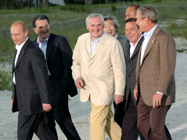 His yellow suit stood out among this walk on the beach with world leaders like Vladimir Putin and George W Bush