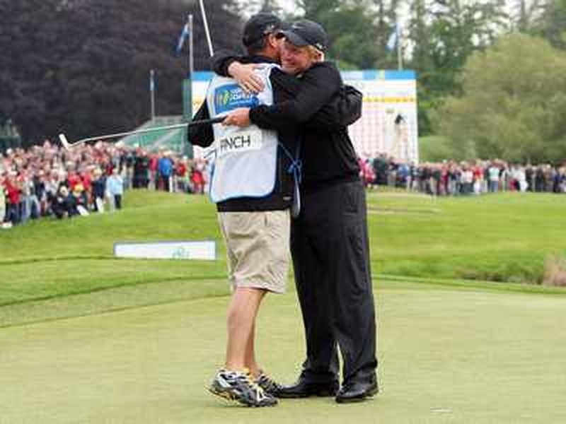 Richard Finch celebrates with his caddy Damien Moore after holing his final putt on the 18th green