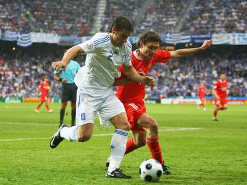 Giourkas Seitaridis of Greece is tackled by Russia's Yuri Zhirkov