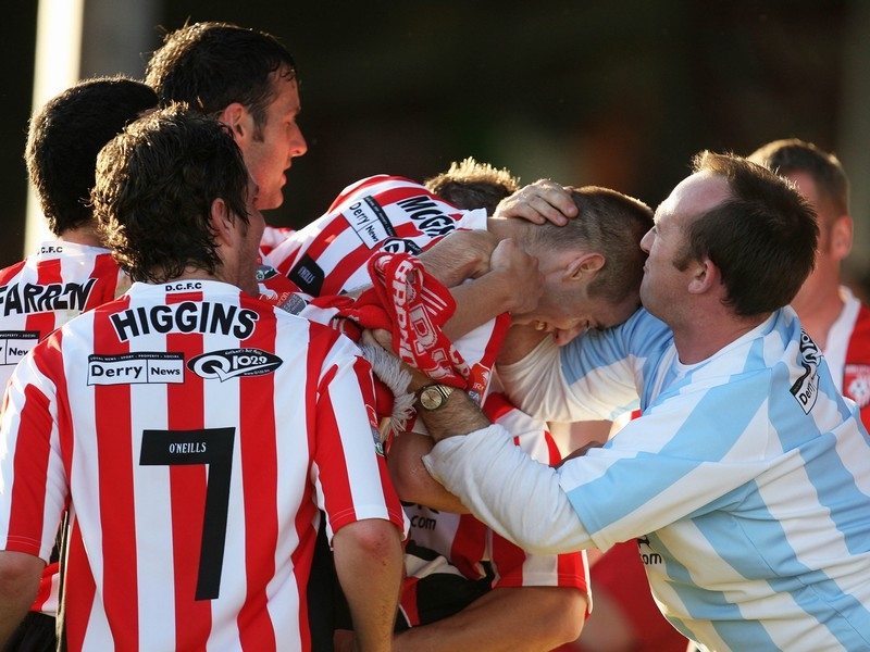 Derry's Niall McGinn celebrates with a fan after scoring the first goal