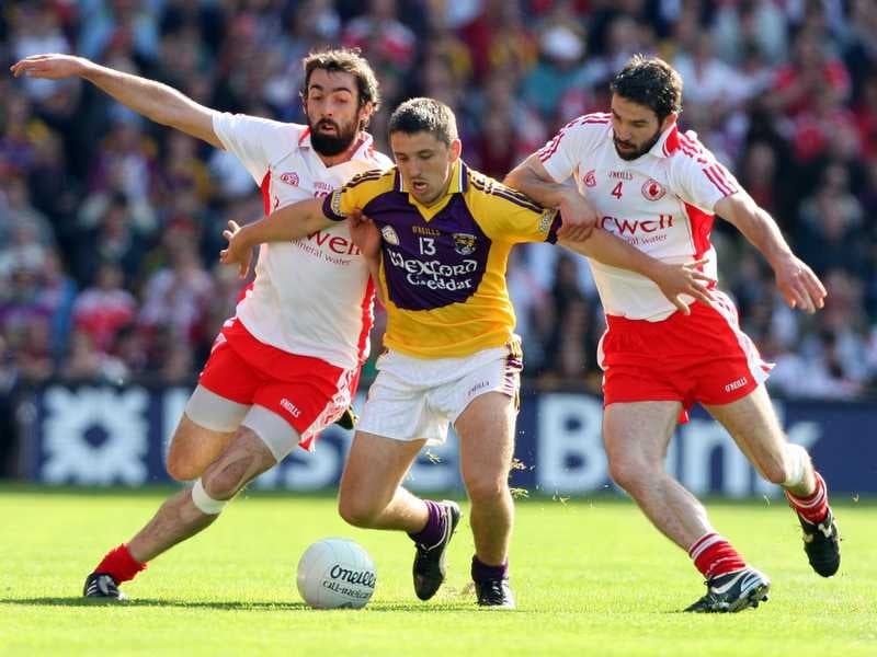 Wexford's Ciarán Lyng tussles with Tyrone's Joe McMahon and Ciaran Gourley