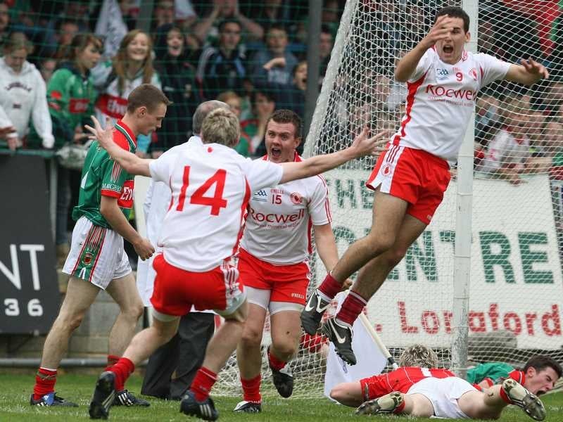 Tyrone's Conor O'Neill (centre) celebrates scoring a goal with Paddy McNeice (14) as Martin Rogers jumps in the air