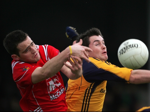 Shane Lennon of Louth (in red) struggles with DCU's Ciaran Hughes