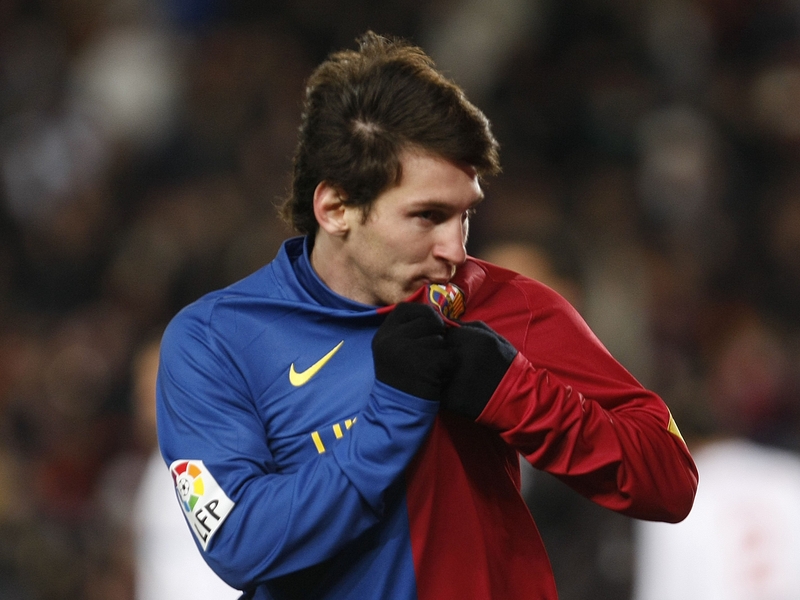 Lionel Messi kisses the Barca badge