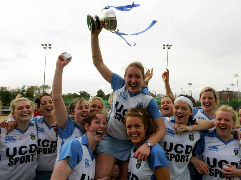Lisa Jacob raises the cup with her victorious UCD side