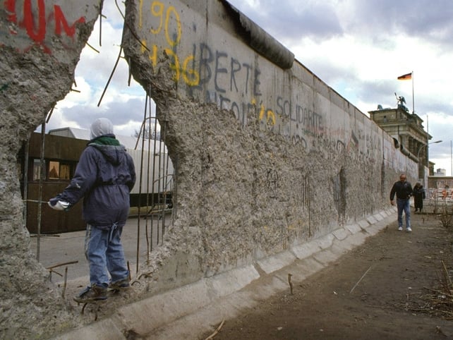 A young boy looks through a hole in the wall towards East Berlin. 14 Nov 1989