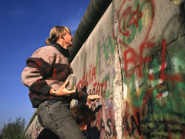 A woman tries to break a hole in the wall at the site of today's Potsdamer Platz, West Berlin 15 Nov 1989