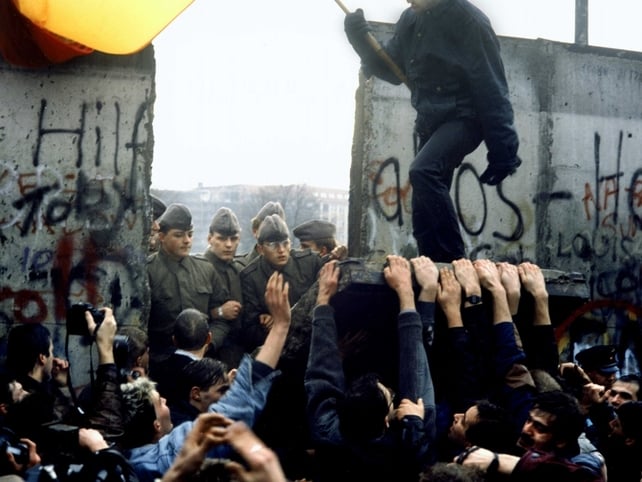 East and West Germany reunite with the tearing down of the Berlin Wall opening all the country's borders. East and West Germans Nov 1989