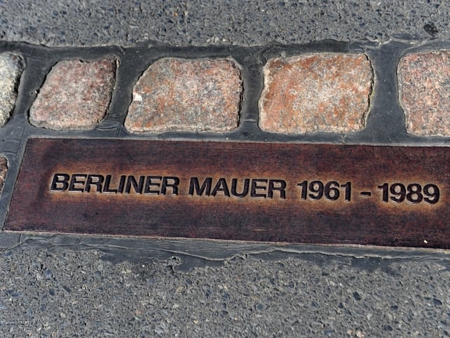 A plaque marks the site where the wall once ran through central Berlin