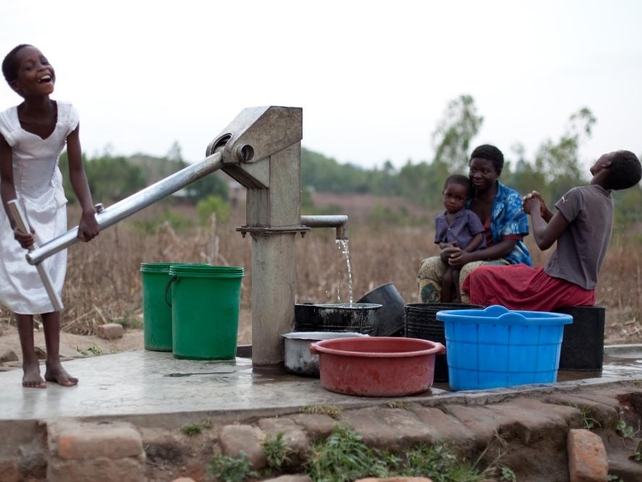 Nine-year-old Rebecca Nyalugwe enjoying helping her family by drawing water from the Sumani village Oxfam Borehole.