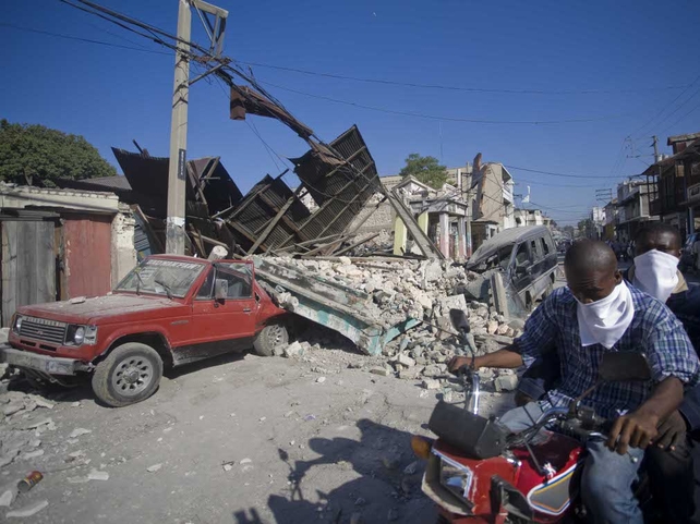 Residents cover their mouths against the smell from decomposing bodies