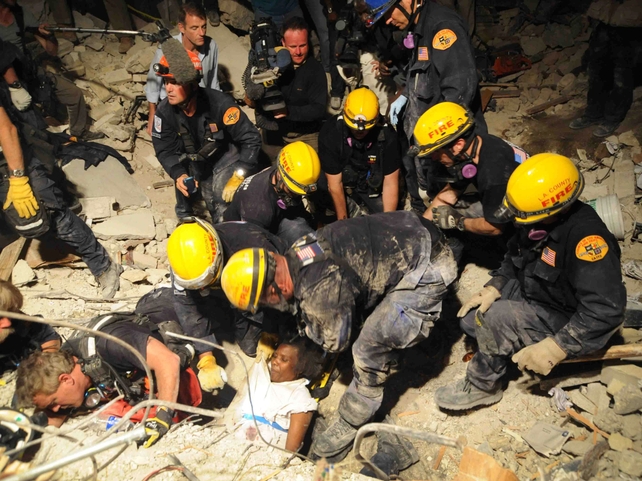 A woman is pulled from the rubble in Port-au-Prince by volunteers from the Los Angeles Fire Department