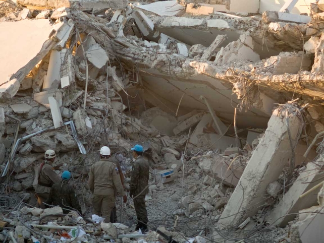 Foreign rescuers work on the debris at the headquarters of the UN Stabilisation Mission in Port-au-Prince