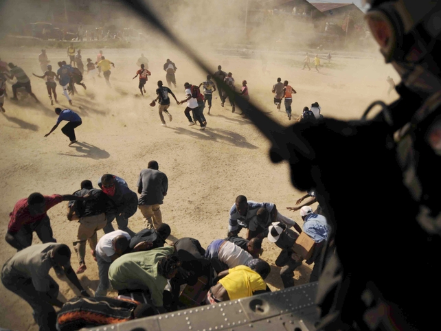 A US helicopter crewman drops humanitarian aid in support of earthquake relief efforts