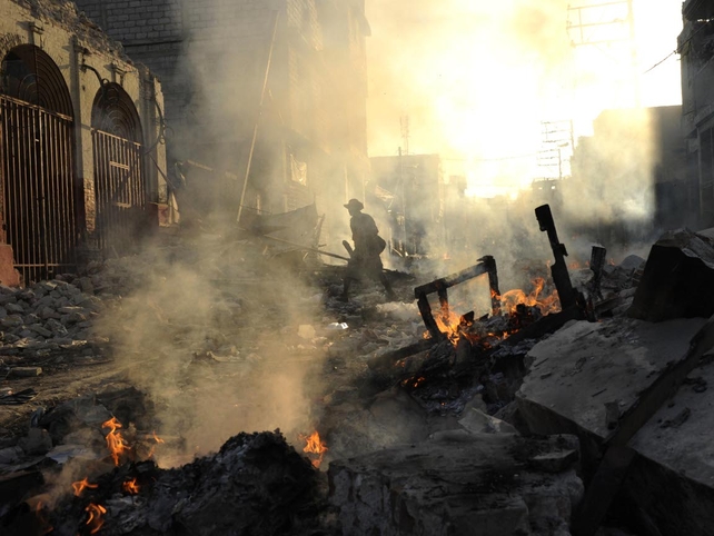 Smoke from burning rubbish adds to the eerie scene of a rubble-filled downtown Port-au-Prince