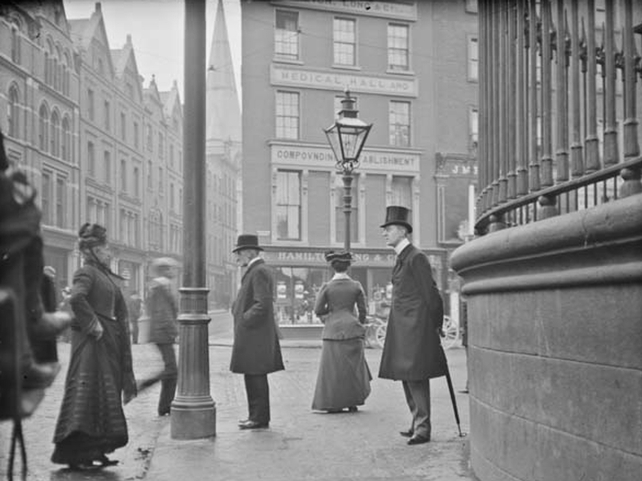 Man with umbrella standing at the junction of Nassau Street, Grafton Street and Suffolk Street. View from Nassau Street. Clarke Collection: 1890-1910