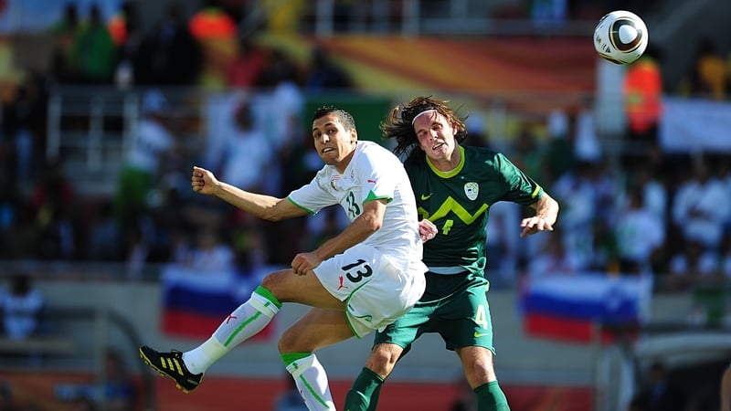 Algeria's Karim Matmour (left) and Slovenia's Marko Suler soar to meet the Jabulani ball