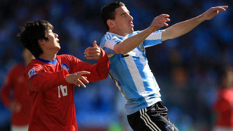 Argentina's Maxi Rodriguez Maxi and South Korea's Sung-Yong have their eye on the ball in Soccer City