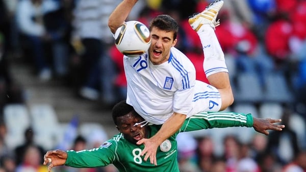 Yakubu Aiyegbeni of Nigeria is challenged by Sokratis Papastathopoulos of Greece in the Bloemfontein Stadium