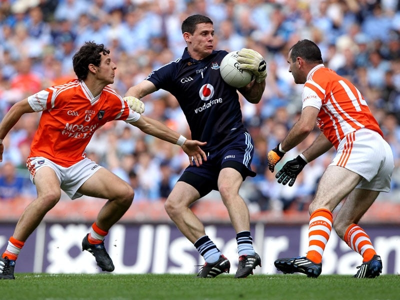 Dublin goalkeeper Steven Cluxton gathers the ball despite the attention of Jamie Clarke (left) and Stevie McDonnell