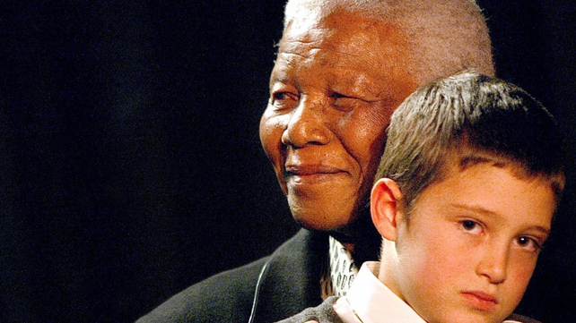 Nelson Mandela and Josh Kovarsky listen to the Soweto Gospel choir sing a song in praise of Mandela at a party to celebrate his 85th birthday