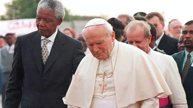 President Nelson Mandela walks with Pope John Paul II after the pontiff's arrival in 1995 on his first official visit to South Africa