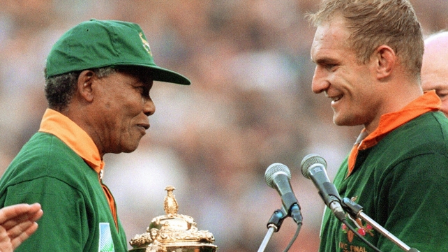 Nelson Mandela congratulates captain Francois Pienaar before handing him the William Webb trophy after his team's victory over New Zealand (15-12) in the final of the Rugby World Cup at Ellis Park in Johannesburg 1995