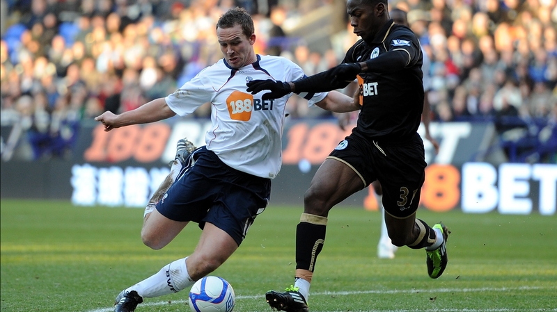 Bolton striker Kevin Davies attempts to get a shot off as Maynor Figueroa of Wigan gets back to defend
