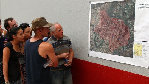 Perth - Local residents inspect map outling fire damage