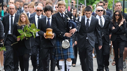 Seve Ballesteros funeral - Mourners walk in procession with a piper as Seve Ballesteros' son Javier carries the urn containing his ashes