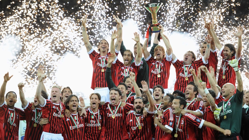 AC Milan players hold the Scudetto trophy aloft after winning the Serie A title at the San Siro