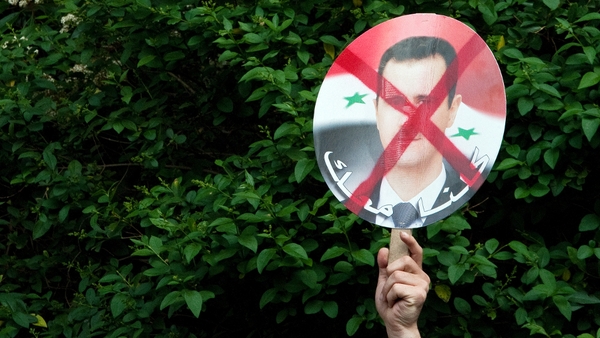 Protests - A protestor waves a placard criticising Syria's president during a demonstration in London