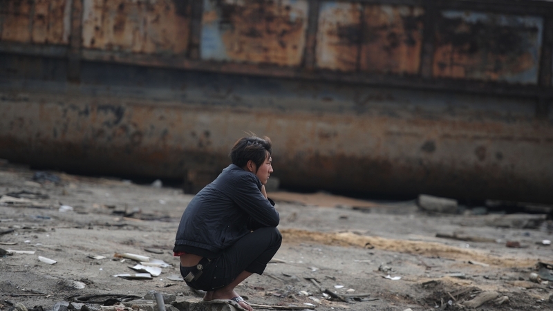 China - A fisherman squats on the dried up banks of the Yangtze River