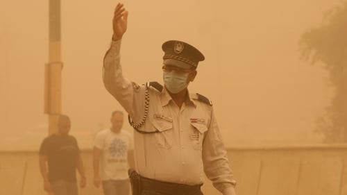Baghdad - Policeman directing traffic in poor visibility conditions