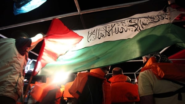Mavi Marmara - Turkish human-rights activist hold a Palestinian flag hours before the Israeli Navy attack