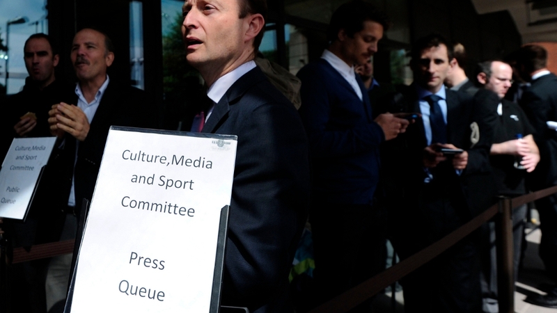 Journalists queue to attend the committee looking into the phone hacking scandal
