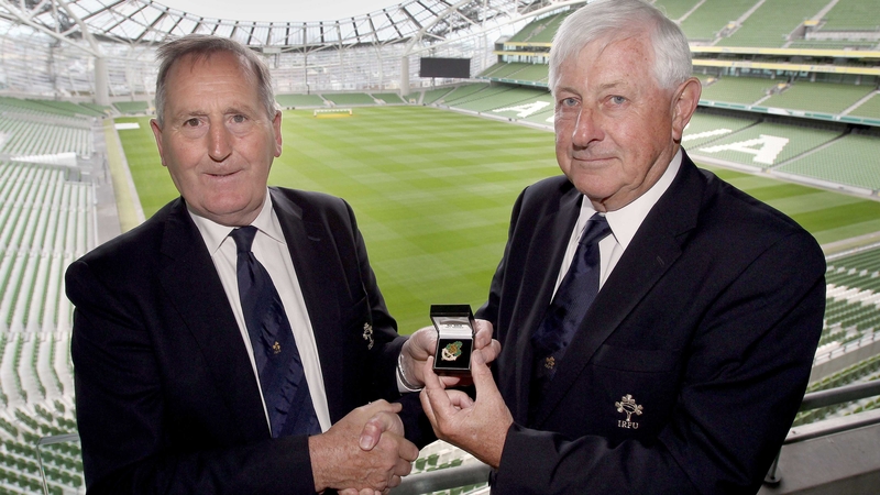 Outgoing IRFU president Caleb Powell (left) hands over the badge of office to John Hussey