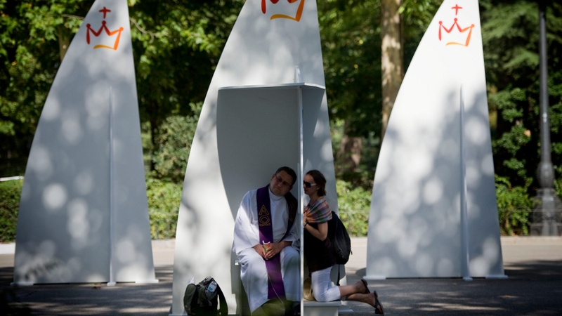 A priest listens to a confession at one of the 200 temporary confessionals set up at Buen Retiro Park