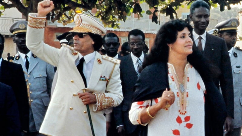 Muammar Gaddafi and his wife Safia wave to the crowd in 1985 in Dakar, Senegal