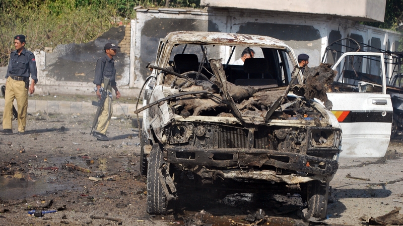 Pakistani police secure the site of the double suicide bomb attack