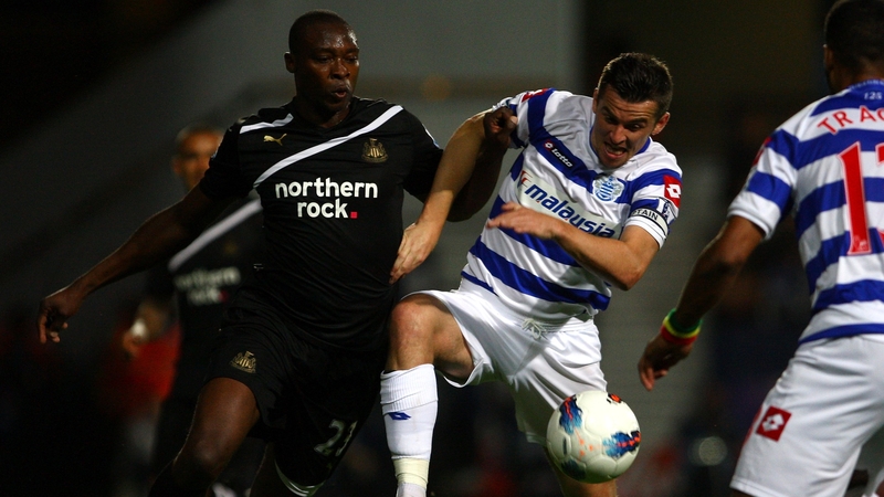 New QPR signing Joey Barton comes under pressure from Shola Ameobi (r)