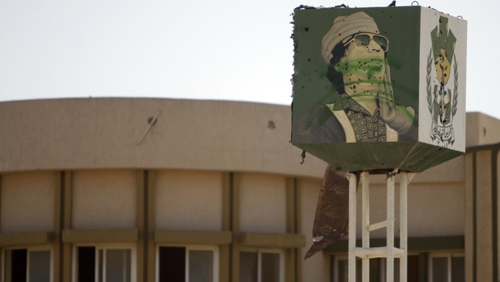 A bullet-riddled portrait of Muammar Gaddafi is pictured at the entrance of the desert town of Bani Walid