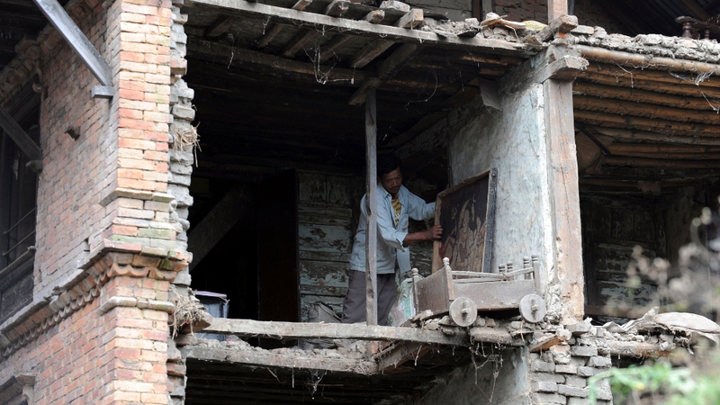A Nepalese resident clears his home from debris following the earthquake